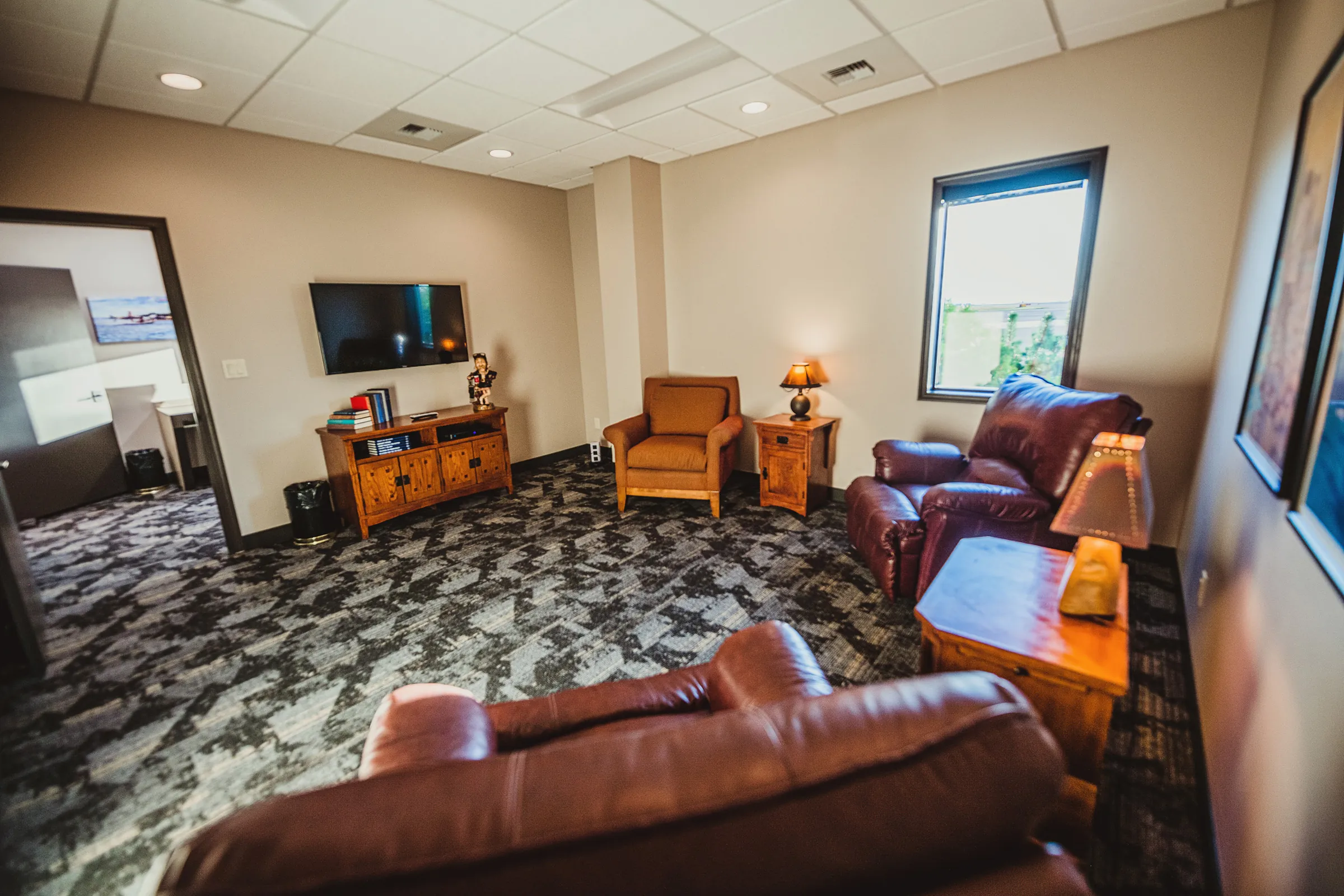 Comfortable seating and tv area with carpeted floors and soft lighting