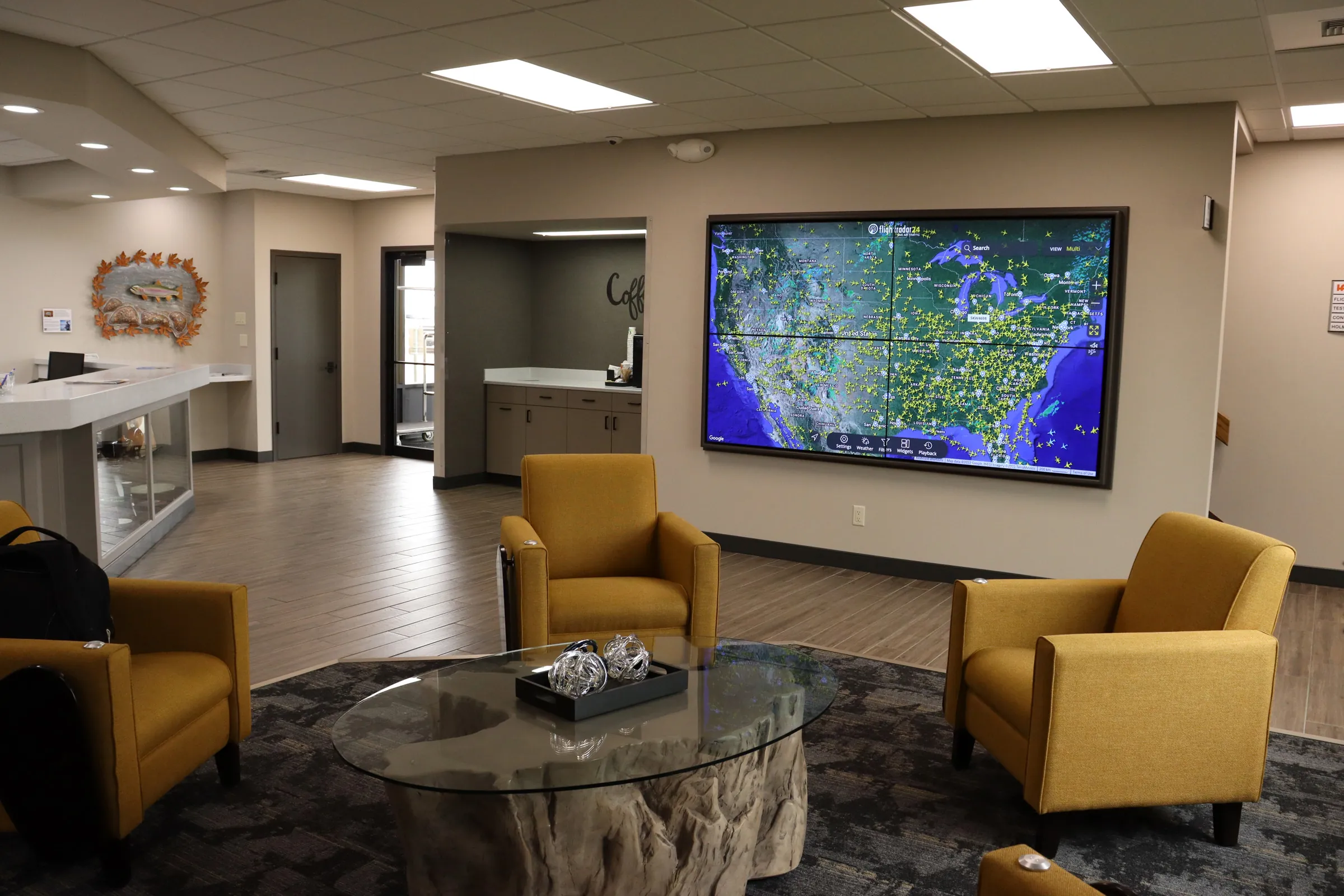 Lobby with yellow chairs and large map of flights